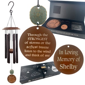 May include: A brown metal wind chime with a round, engraved metal tag that reads "Through the STRONGEST of storms or the softest breeze listen to the wind and think of me". The wind chime is packaged in a black box with a white cloud design and the words "Comfort Through the Storm".