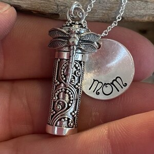 May include: Silver necklace with a dragonfly charm and a round pendant that says "MOM".
