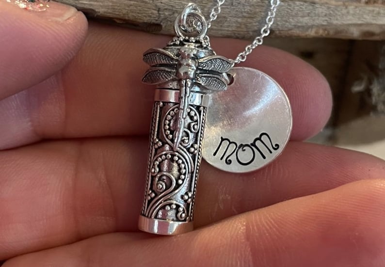 May include: Silver necklace with a dragonfly charm and a round pendant that says "MOM".