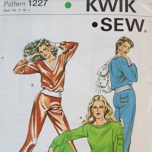 May include: A vintage sewing pattern from Kwik Sew, pattern 1227, featuring illustrations of three different tracksuits. The tracksuits are in shades of orange, green, and blue. The pattern includes sizes XS to L. The designer is Kerstin Martensson.