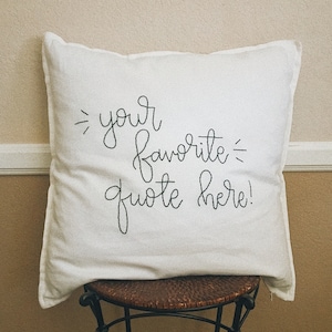 May include: White pillow with black embroidered text that reads "your favorite quote here!"