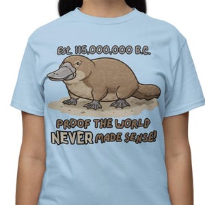 Camiseta de ornitorrinco prehistórico: prueba de que el mundo nunca tuvo sentido. Camiseta gráfica con humor sarcástico sobre la evolución.