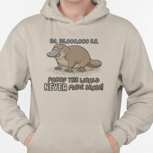 Sudadera con capucha de ornitorrinco prehistórico: prueba de que el mundo nunca tuvo sentido. Camiseta gráfica con humor sarcástico sobre la evolución.