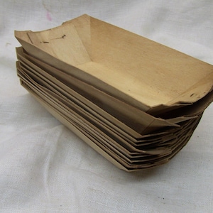 May include: A stack of brown paper food trays, likely for takeout or delivery. The trays are made of a sturdy, disposable material and are ready to be used.