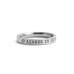 Op de afbeelding: Een zilveren ring met de inscriptie "ALWAYS IN MY HEART" en een klein vleugelontwerp.