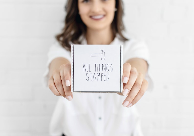 May include: A white box with the text "ALL THINGS STAMPED" and a small illustration of a hammer.