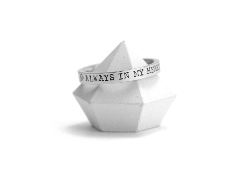 Op de afbeelding: Een zilveren ring met de inscriptie "ALWAYS IN MY HEART".
