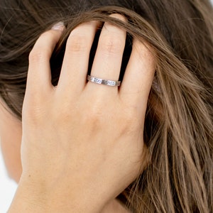Op de afbeelding: Een zilveren ring met de inscriptie "This Too Shall Pass" gegraveerd op de band.