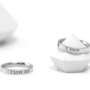 May include: Two silver rings with the words "I love you" and "I know" engraved on them.