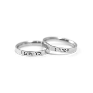 May include: Two silver rings with the words "I love you" and "I know" engraved on them.