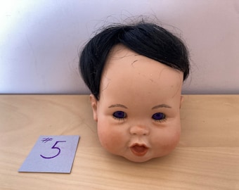 Porcelain half-dolls, doll heads and busts with light skin and blonde, gray, and black hair and two porcelain doll heads from Asian dolls