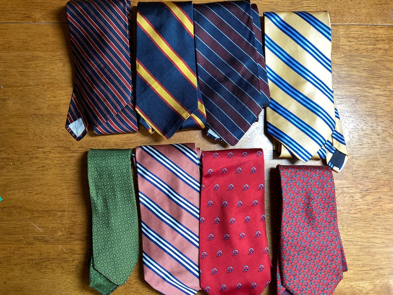 Puede incluir: Una colecci&oacute;n de diez corbatas a rayas y estampadas en varios colores, incluyendo rojo, azul, verde, amarillo y marr&oacute;n.
