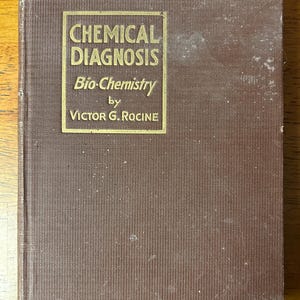 May include: A brown hardcover book titled "CHEMICAL DIAGNOSIS" with gold lettering. The subtitle reads "Bio-Chemistry" by Victor G. Rocine. The book has a worn appearance with some damage to the cover.