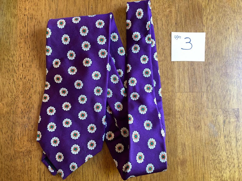 Varias corbatas vintage de Brooks Brothers adornadas con rayas (¡no es ninguna sorpresa!) y una corbata violeta brillante (bastante sorprendente) con margaritas. #3 Purple daisies