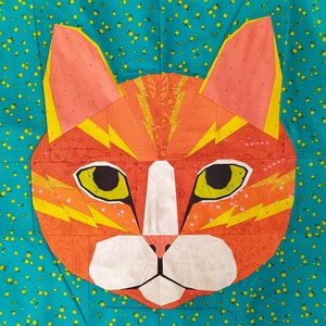 Könnte beinhalten: Ein farbenfrohes Patchwork-Katzenmotiv mit orangefarbenen, gelben und weißen Akzenten. Das Gesicht der Katze ist schwarz umrandet und hat eine weiße Nase und Schnurrhaare.