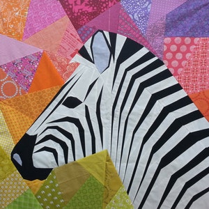 May include: A black and white zebra head quilt block with a colourful patchwork background. The quilt block is made of fabric squares sewn together in a geometric pattern.