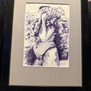 May include: A framed pen and ink drawing of a person with a full figure, with arms raised and covering the face. The drawing is in shades of blue and white, with a gray mat and black frame. The artwork is signed.