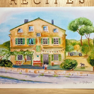 Puede incluir: Una pintura de acuarela de una casa amarilla con contraventanas verdes y un techo rojo. La casa está rodeada de árboles y flores. La pintura está firmada "Al Hysballe" y titulada "The Burrells House".