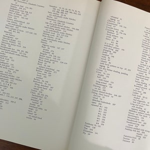 May include: Open book with a detailed index of embroidery stitches and techniques. The pages are filled with text, including terms like "Bargello," "Chain," and "Fishbone." The book is open to a page with the index.
