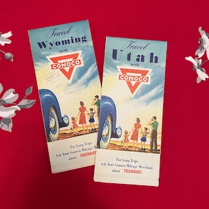 May include: Two vintage travel brochures for Wyoming and Utah, featuring a car and family, with the Conoco logo and the text "Travel Wyoming with Conoco" and "Travel Utah with Conoco".