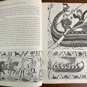 May include: Open book with a detailed illustration of the Bayeux Tapestry. The black and white drawings depict scenes of historical battles, boats, and figures. Text on the page includes the title "ERICA WILSON'S EMBROIDERY BOOK" and descriptive text about the tapestry.