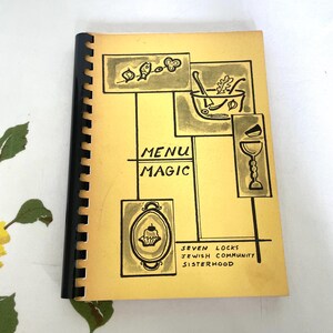 May include: A vintage cookbook titled "Menu Magic" with a spiral binding. The cover is yellow with black illustrations of food items and the text "Menu Magic". The cookbook is from the Seven Locks Jewish Community Sisterhood.