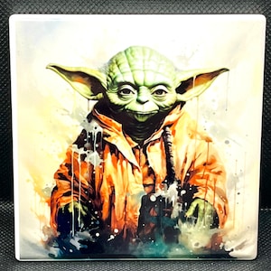 May include: A green and orange watercolour painting of Yoda from Star Wars. The painting has a white splattered background.