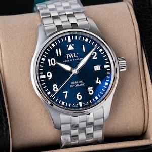Peut inclure: Une montre-bracelet automatique IWC Schaffhausen Mark XX en acier inoxydable avec un cadran bleu profond, des chiffres arabes blancs, un guichet de date à trois heures et un bracelet à maillons en métal argenté avec film protecteur.