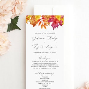 May include: A wedding ceremony programme with autumn leaves in the background. The programme lists the order of events for the wedding of Juliana Bishop and Ryurt League, taking place at Lake Belle Vineyard on 15th November 2023.