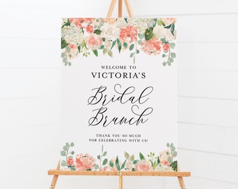 May include: A white sign with a floral border and the text "Welcome to Victoria's Bridal Brunch. Thank you so much for celebrating with us!"