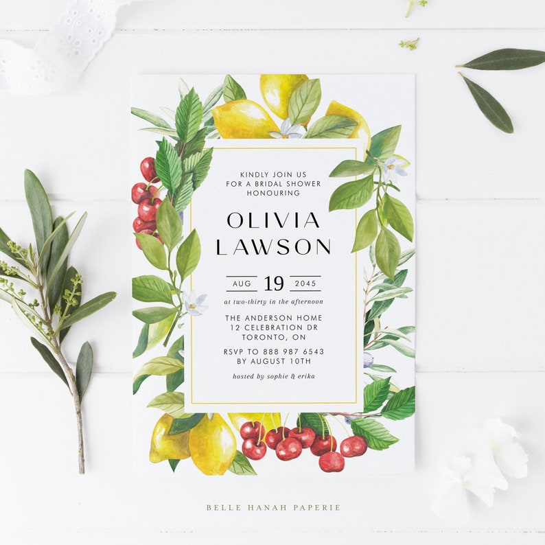 May include: A white bridal shower invitation with a gold border. The invitation features a watercolor illustration of lemons, cherries, and greenery. The text reads "Kindly join us for a bridal shower honouring Olivia Lawson, Aug 19, 2045 at two-thirty in the afternoon, The Anderson Home, 12 Celebration Dr, Toronto, ON, RSVP to 888 987 6543 by August 10th, hosted by Sophie & Erika, Belle Hanah Paperie."