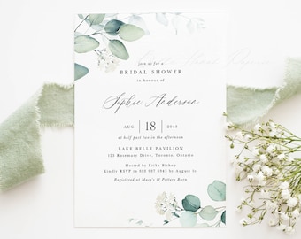 May include: A white bridal shower invitation with a watercolor design of eucalyptus leaves and white flowers. The invitation includes the text "join us for a BRIDAL SHOWER in honour of Sophie Anderson AUG | 18 | 2045 at half past two in the afternoon LAKE BELLE PAVILION 123 Rosemary Drive, Toronto, Ontario Hosted by Erika Bishop Kindly RSVP to 888 987 6543 by August 1st Registered at Macy's & Pottery Barn"