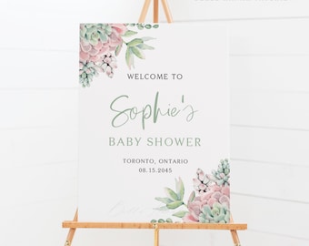 May include: A welcome sign for a baby shower with a watercolor illustration of succulents in shades of green and pink. The sign reads "Welcome to Sophie's Baby Shower, Toronto, Ontario, 08.15.2045".