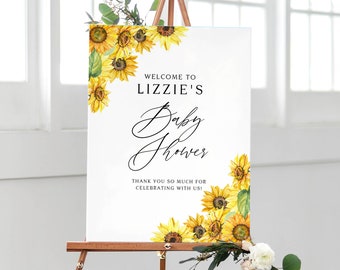 May include: Welcome to Lizzie's Baby Shower sign with a sunflower design. The sign is white with black text and features a watercolor illustration of sunflowers.