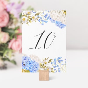 Pode incluir: Cartão de número de mesa de casamento floral branco e azul com o número 10 impresso em preto.