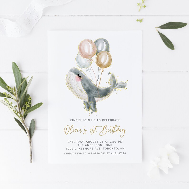 May include: A watercolor illustration of a whale with gold glitter holding balloons in shades of pink, blue, and gold. The text reads "Kindly join us to celebrate Oliver's 1st Birthday. Saturday, August 28 at 2:00 PM. The Anderson Home. 1092 Lakeshore Ave, Toronto, ON. Kindly RSVP to 888 9876 543 by August 20."