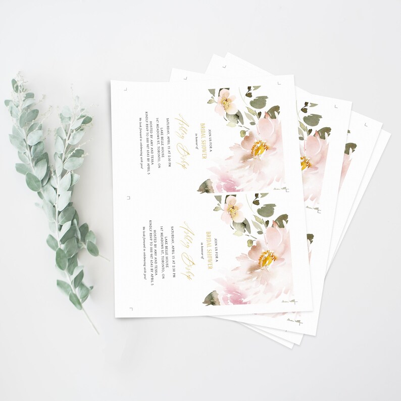 May include: A stack of white bridal shower invitations with a watercolor floral design in shades of pink and green. The text on the invitation reads "Join us for a Bridal Shower" and "Ashley Bishop".