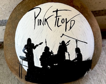 Silueta y emblema de Pink Floyd pintados en la parte delantera y trasera de una roca. Aproximadamente 5" x 5" x 2".