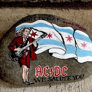 AC/DC Angus Young  painted on a large rock