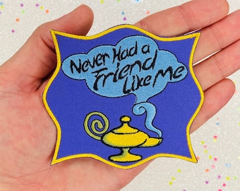 May include: A blue and yellow embroidered patch with a genie lamp and a speech bubble that says "Never had a friend like me".