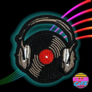 May include: An embroidered patch featuring a black and grey vinyl record with headphones on top. The record has a red centre label.