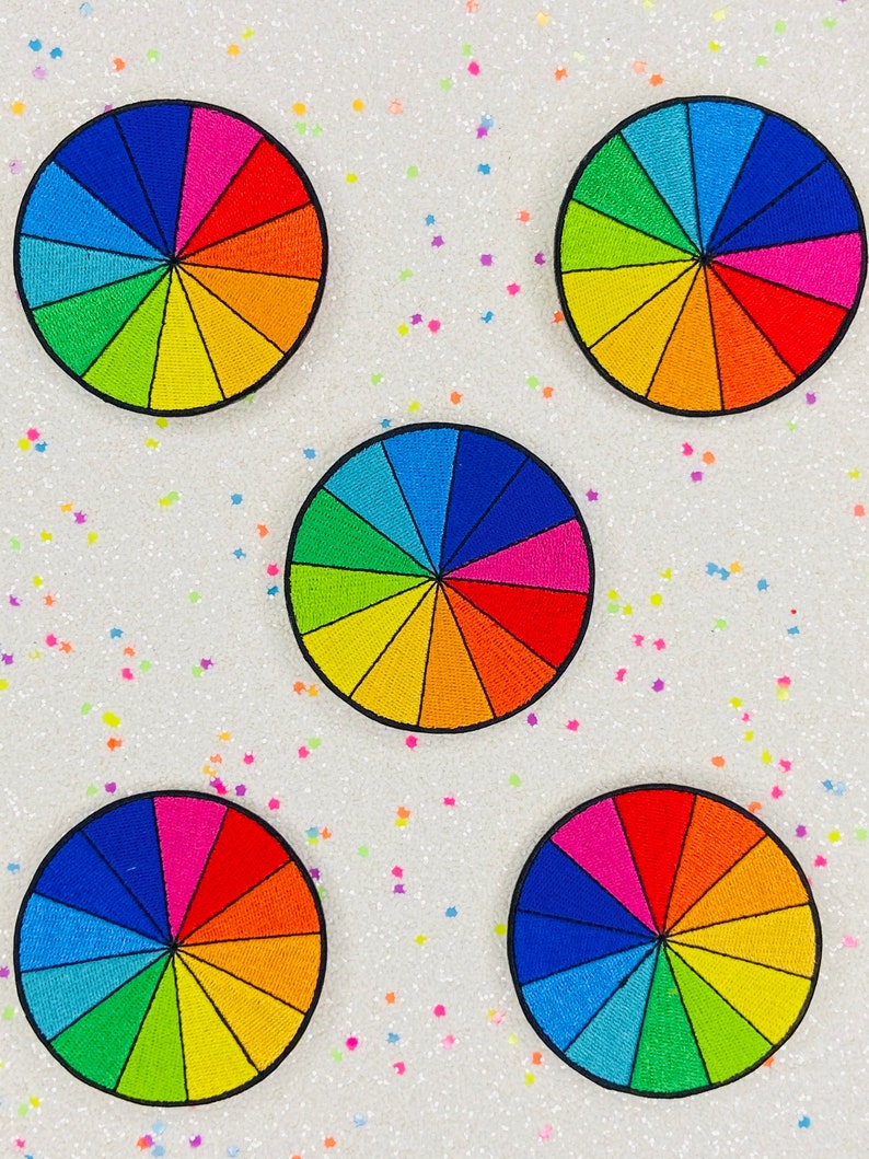 May include: Five colorful embroidered patches in the shape of a color wheel. Each patch has 12 sections of different colors, including red, orange, yellow, green, blue, and purple.