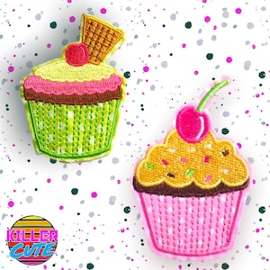 May include: Two embroidered cupcake patches. The first cupcake is green with white polka dots and a pink frosting swirl. It has a cherry on top and a brown waffle cone. The second cupcake is pink with white polka dots and yellow frosting with brown sprinkles. It has a pink cherry on top.