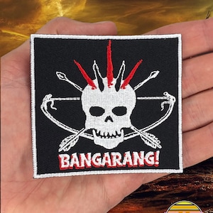 May include: Black and white embroidered patch with a skull with red spikes on top. The skull is holding crossed arrows and the text "Bangarang!" is below the skull.