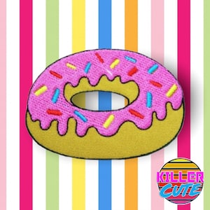 May include: Pink and yellow donut with sprinkles, embroidered on a fabric patch. The donut is on a striped background with the words "Killer Cute" in a retro font.