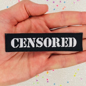 May include: A black fabric patch with white embroidered text that reads "CENSORED".