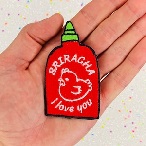 May include: Red embroidered iron-on patch shaped like a sriracha bottle with a white chicken and the text "Sriracha I love you".