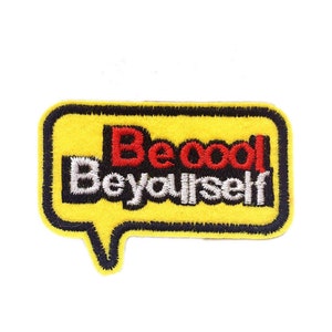 May include: Yellow embroidered iron-on patch with a speech bubble shape. The text inside the bubble reads "Be cool Be yourself" in red, white, and black lettering.