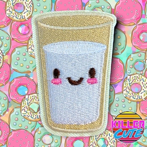 May include: A white embroidered patch depicting a smiling glass of milk with a beige rim. The patch is surrounded by a pattern of pink and green doughnuts with sprinkles.