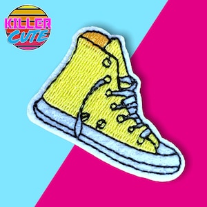 May include: Yellow embroidered iron-on patch of a high-top sneaker with white laces and a blue outline.